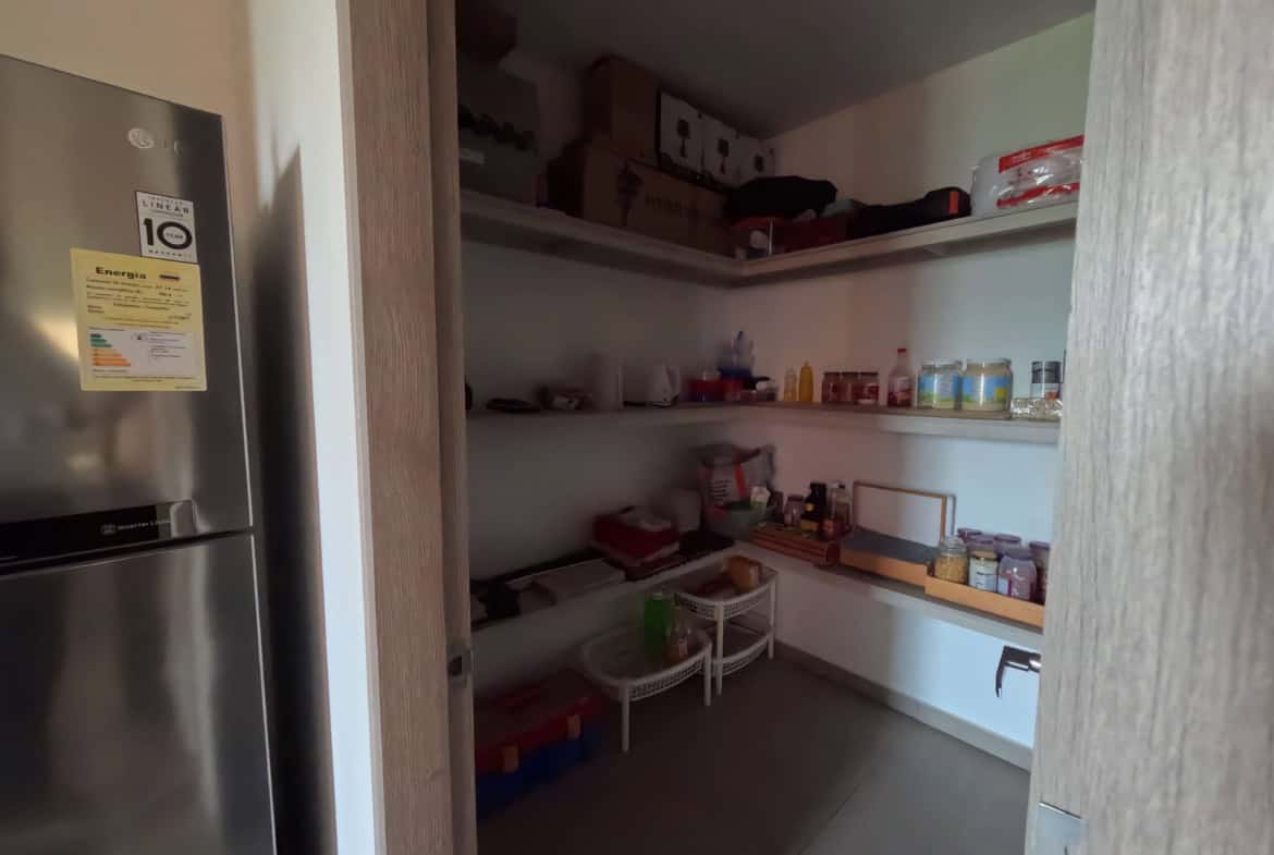 Espacio de almacenamiento en apartamento de 200m2 en Calambeo, Ibagué, con estanterías llenas de pro.