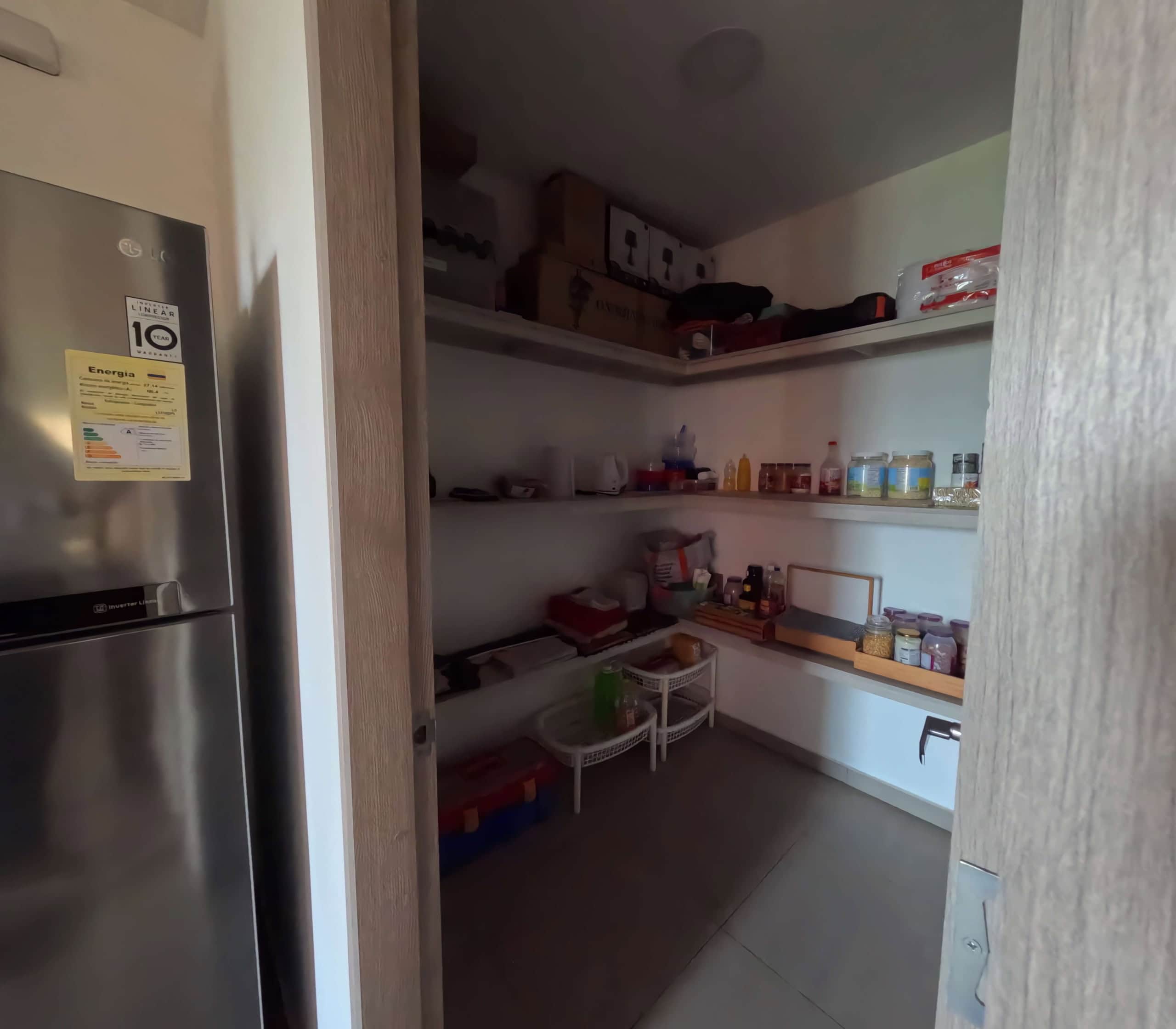 Espacio de almacenamiento en apartamento de 200m2 en Calambeo, Ibagué, con estanterías llenas de pro.