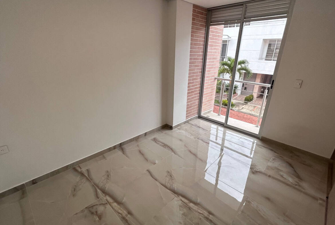 Puerta corrediza de vidrio en sala con vista a la ciudad.