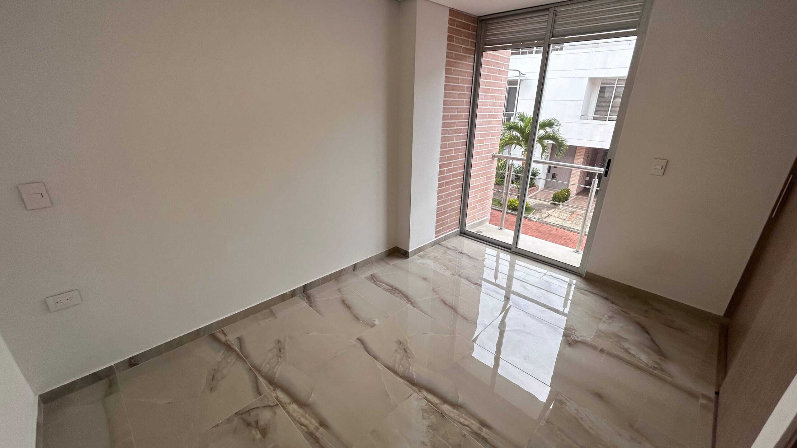 Puerta corrediza de vidrio en sala con vista a la ciudad.