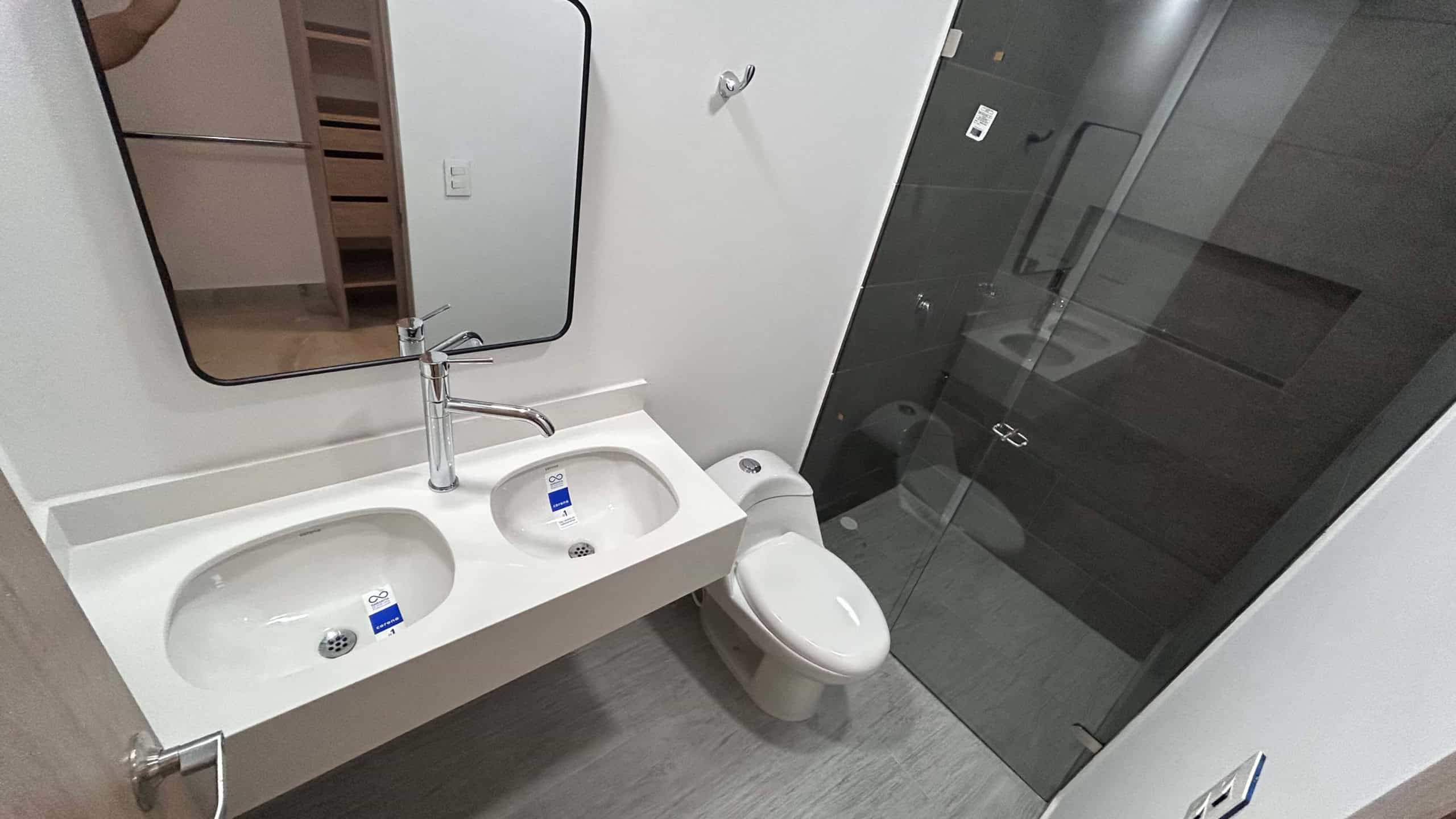 Baño en condominio La Samaria, Ibagué, con doble lavamanos y ducha moderna.