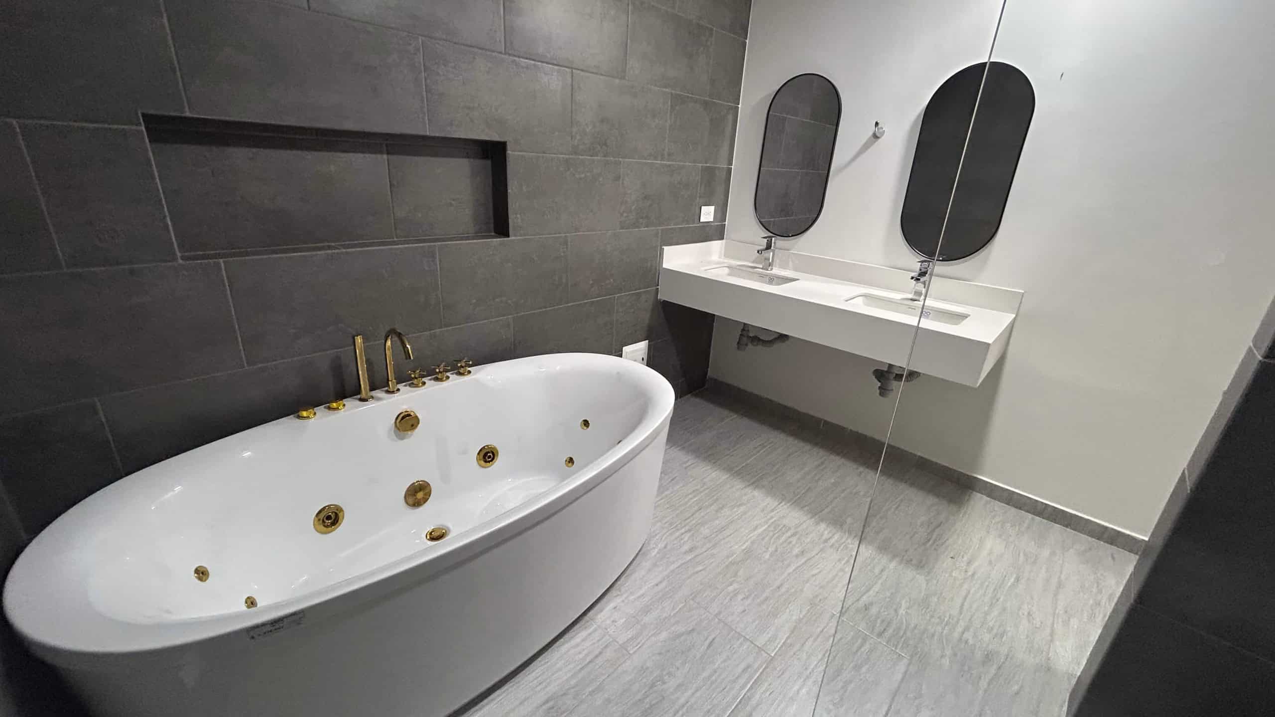 Baño elegante con jacuzzi y doble lavabo en condominio La Samaria, Ibagué.