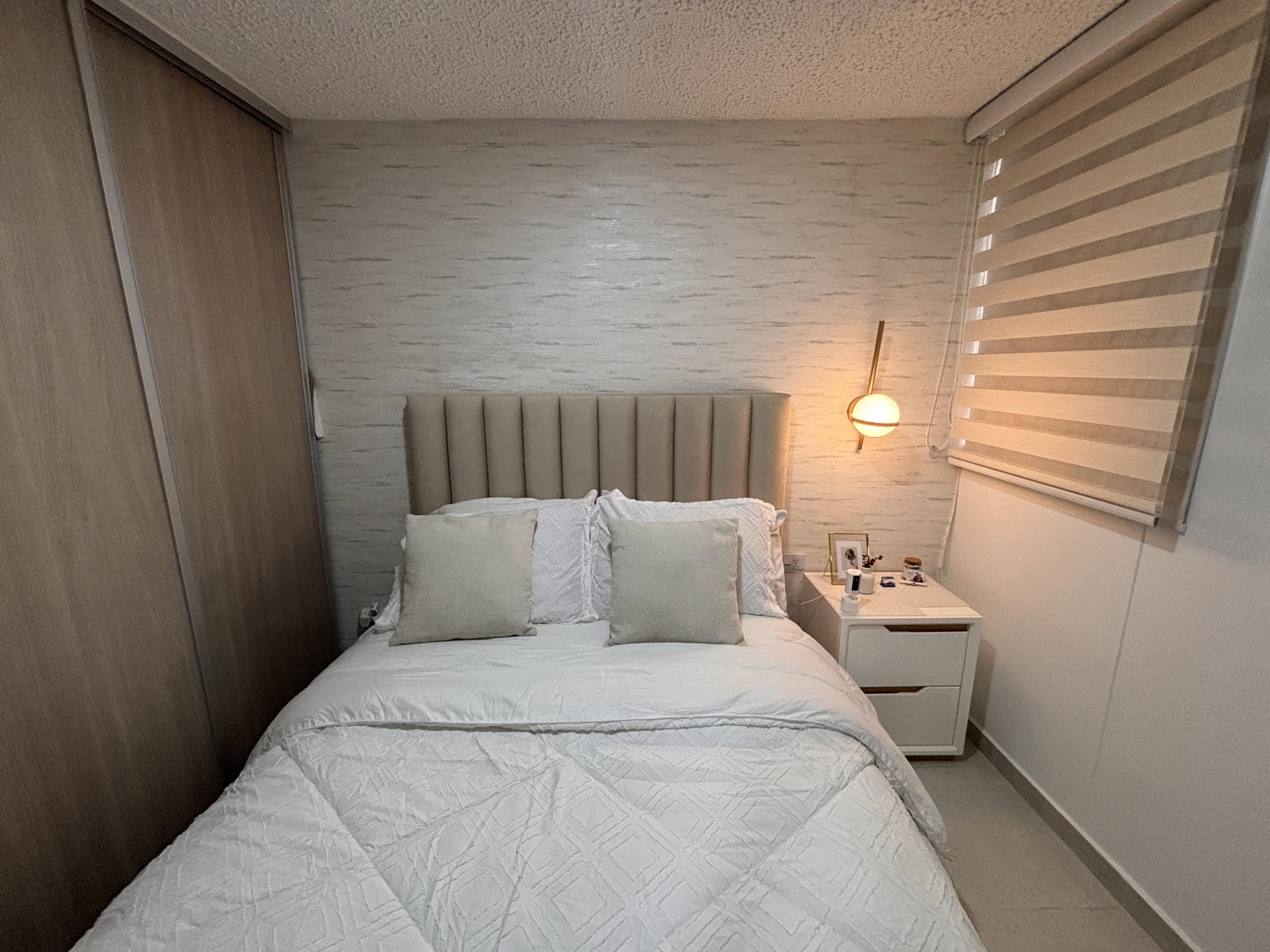 Amplio dormitorio con cama y decoración elegante en apartamento en Ibagué.